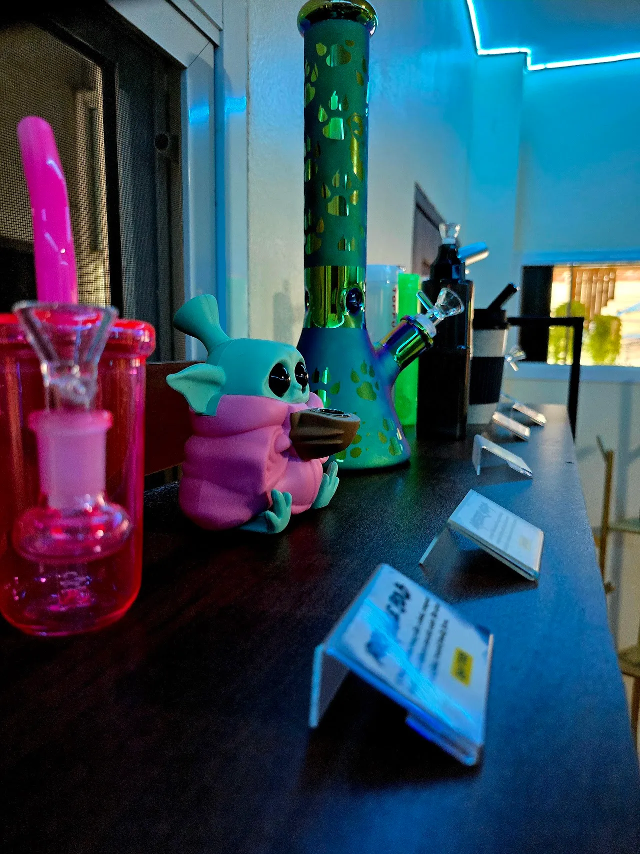 Glassware and accessories on the counter under neon light
