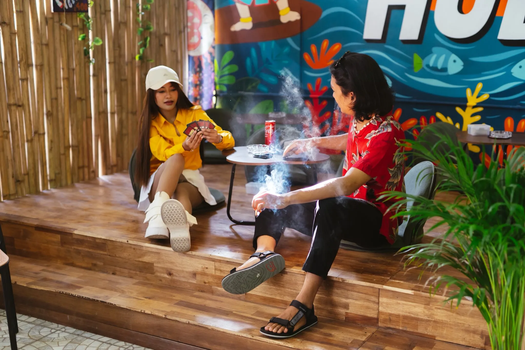 Guests relaxing at a table in The Hub bamboo garden lounge