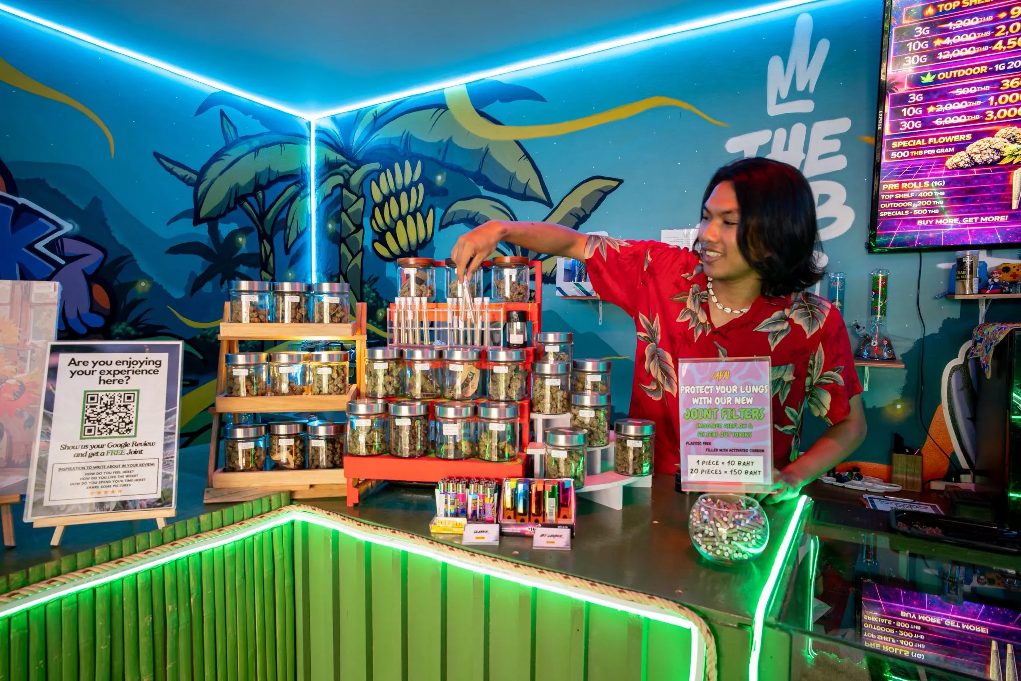 Neon-lit interior with palm mural and the cannabis counter